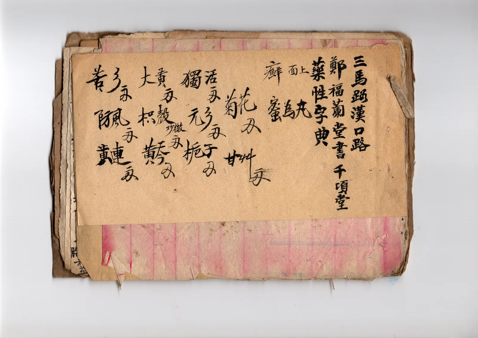 这张图片展示的是郑福兰堂留存的一份老旧手写处方，属于该文档提及的老处方范畴。处方书写在泛黄的纸上，字迹为黑色毛笔书法，部分笔画因年代久远略显模糊，纸张和周围的册子边缘已有破损、褶皱，能看出岁月留下的痕迹。这份处方上明确写有“郑福兰堂国药号用笺”的字样，还标注了具体的药材名称与用量，部分药材旁附有用法备注，内容涉及治疗相关病症的用药方案，是郑福兰堂传承“大医精诚”理念、用心行医的实物见证，契合文档中关于该堂留存老处方的描述。
